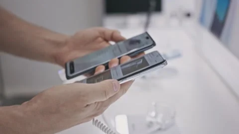 Close-up of a man choosing a smartphone in an electronics hypermarket. In the Stock Footage 251734932