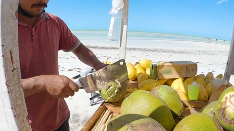 Close up of man chopping end off of green coconut in slow motion Stock Footage 233427956