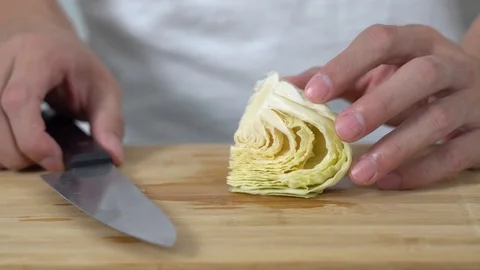 Close up of a man chopping green cabbage vegetables in a kitchen Stock Footage 113515439