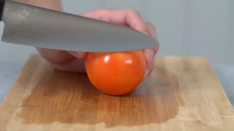 Close up of a man chopping tomato vegetables on chopping board in a kitchen Stock Footage 113515481