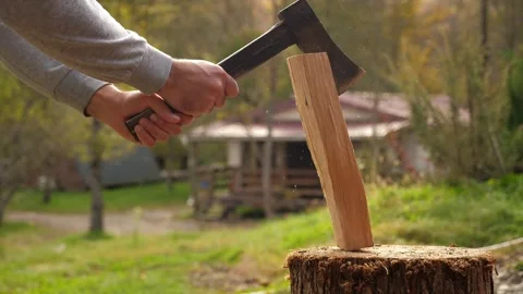 Close-up of a man chopping wood with an axe in the backyard of a house. Stock Footage 294678664