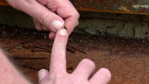 Close up: man cleaning his fingernails with a rusty nail, rusty decaying surface Stock Footage 89306862