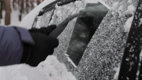 Close up of man cleaning an icy window on a car with ice scraper Vídeos de archivo 258917522