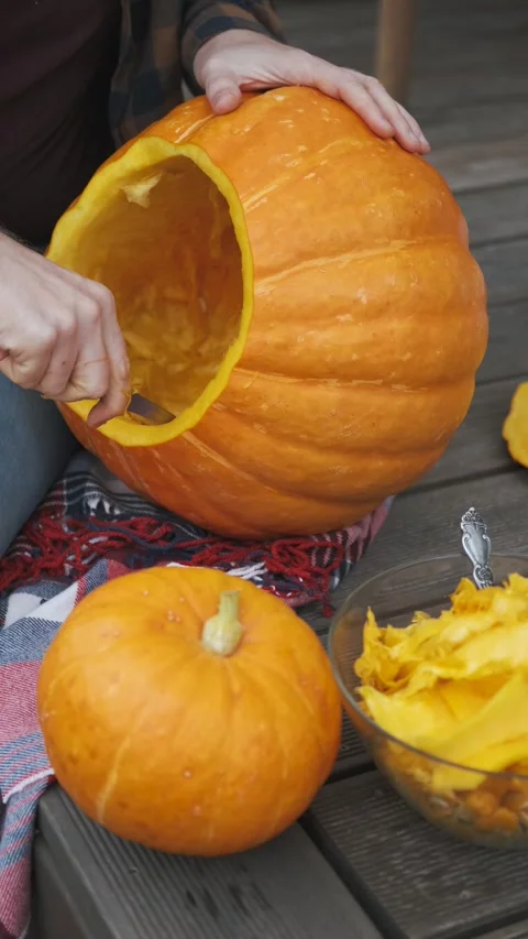 Close-up of a man cleaning out the insides of a pumpkin, vertical video Stock Footage 252047144