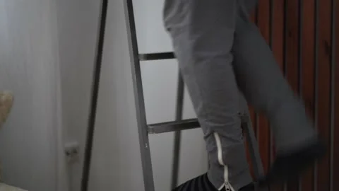 Close-up man climbing ladders at home Stock Footage 168708332