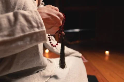 Close-up man in clothes for practice and meditation sits in a lotus pose and Stock Photos