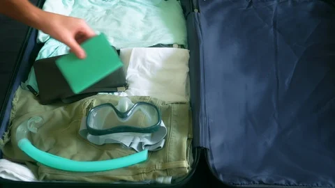 Close-up. man collects a suitcase on a trip to tropical countries with diving Stock Footage 102568552