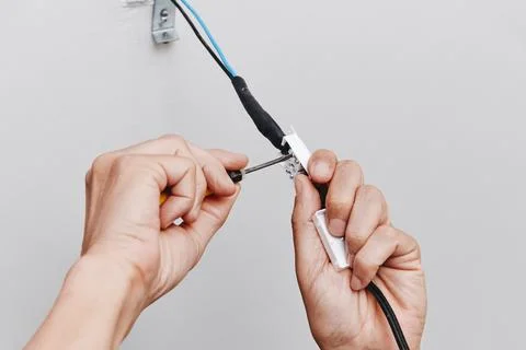 A close-up of a man connecting a ceiling light Stock Photos