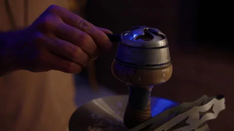 Close-up of a man covering the coals of a hookah before smoking Stock Footage 204842272