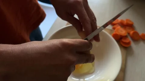 Close-up of a man cracking an egg into a white bowl on a kitchen counter Stock Footage 336524015