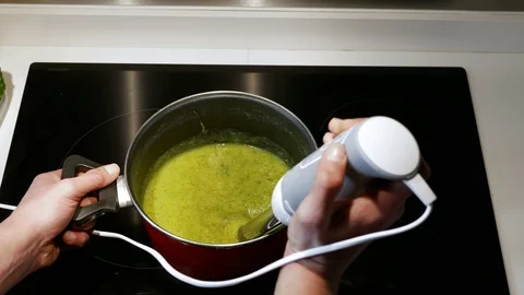 Close up of man crushing vegetables with a mixer. Stock Footage 127928066