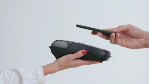 Close up man customer pays with contactless Nfc payment technology on smartphone Stock Footage 219924415