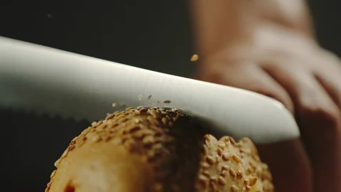 CLOSE UP: Man Cutting A Crispy Baguette With Crumbs On Wooden Board Видео 113783576