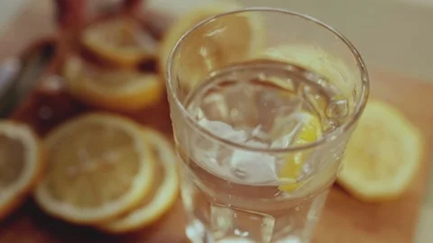 Close up of a man cutting the lemon on a cutting board in kitchen. Lemon juice c Stock Footage 302362319