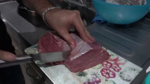 Close-up of a man cutting meat with a knife to prepare the grill with his hands Vidéo 155791700