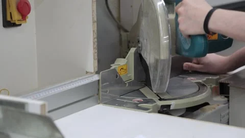 Close-up of a man cutting a plank of wood on a sawing machine in a workshop Stock Footage 302473406