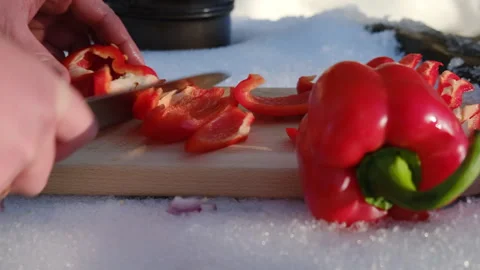 Close up of man cutting red peppers on wooden board on background river Stock Footage 301363913