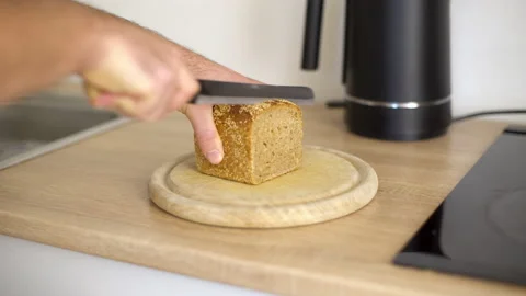 Close up of a man cutting a slice of bread from a loaf 스톡 동영상 170687892