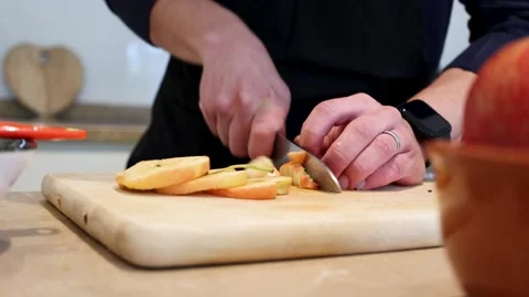 Close up of a man cutting some apples on a wooden board making a dessert Stock Footage 297187628