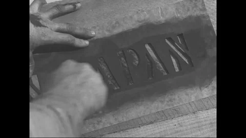 Close up of man depicts Made in Japan on wooden crate - 1940 Stock Footage 103599331
