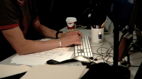 Close up of man at desk typing on computer and going through files Video stock 32708910