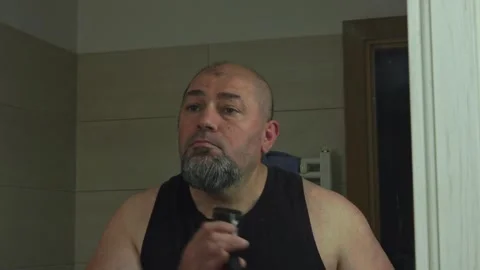 Close-Up of a Man Detailing His Beard Stubble in Bathroom Mirror Stock Footage 337164608