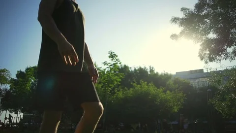 Close up man do knee to chest stretch exercise sun green lawn rapid slow motion Video stock 78037886