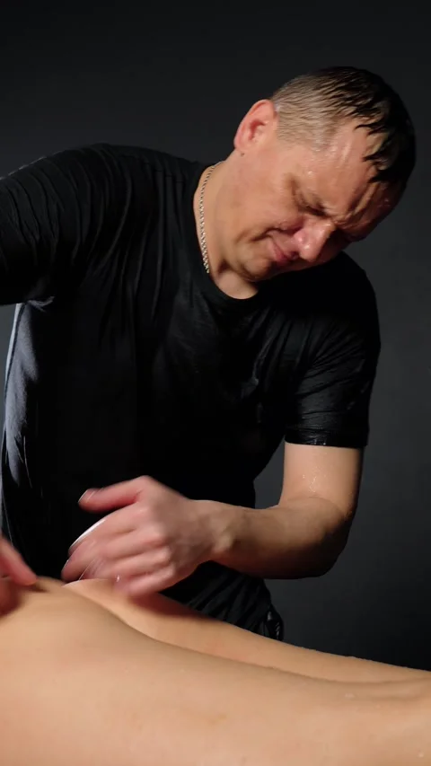 Close up of man does massage by slapping on woman buttocks splashing water Stock Footage 303646385