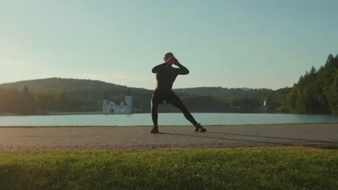 Close up man doing exercise jum near lake at outdoor workout at sunlight Video stock 138641681