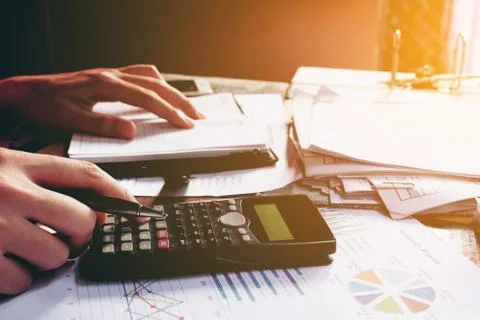 Close up man doing finance and using calculator in home office. Stock Photos