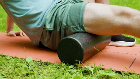 Close-up of a man doing foam rolling on his hamstring for post-workout recovery  Stock Footage 339479372