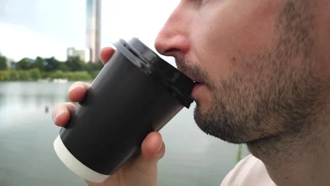 Close-up of a man drinking from a black takeaway cup Stock Footage 283404062