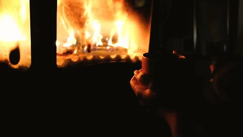 Close up of man drinking coffee or tea in front of a fireplace. girl holding cup Stock Footage 86757382