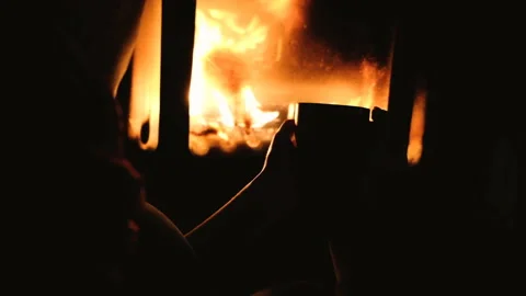 Close up of man drinking coffee or tea in front of a fireplace. girl holding cup Stock Footage 86757542