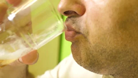 Close-up of a man drinking light beer from a glass during a homemade lunch in Stock Footage 337881742