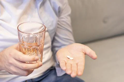 Close-up of a man drinking pills drinking a glass of water holding in his hands Stock Photos
