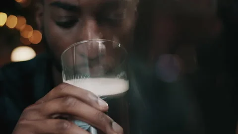 Close up of a man drinking from a pint glass of a porter beer at the bar Stock Footage 132017385