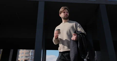 Close up of a man drinking take away coffee. Young man walks around modern urban Stock Footage 237249729