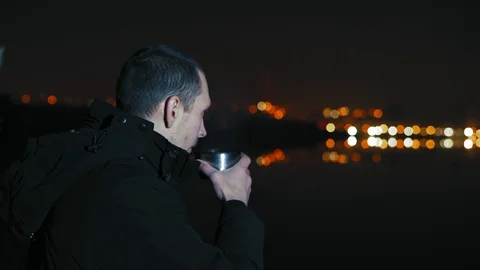 Close-up, Man Drinking Tea on the River Bank Late in the Evening Stock Footage 98568287