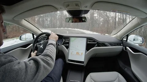 CLOSE UP: Man driving Tesla Model S all-electric car on winding country road Stock Footage 72840324