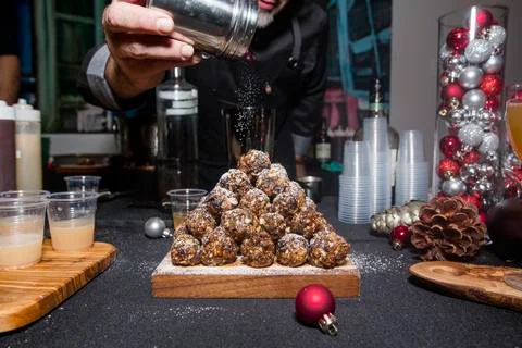 Close-up of man dusting powdered sugar on pyramid of sweets at a party Stock Photos