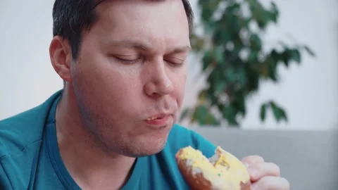 Close-up of a man eating a donut. Stock Footage 148571290