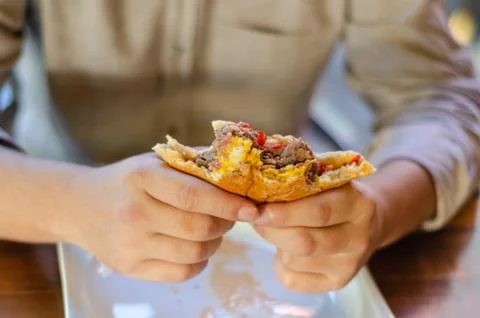 Close up man eating hamburger ,half eaten hamburger. Stock Photos
