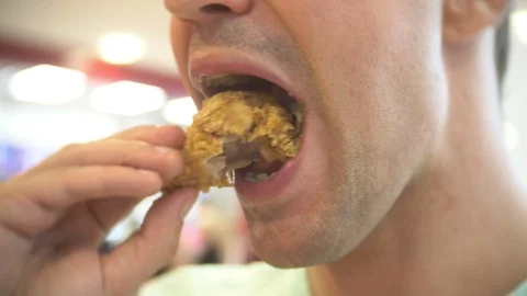 Close-up, man eats, fast food, chicken nuggets, wings and french fries. Stock Footage 88971485