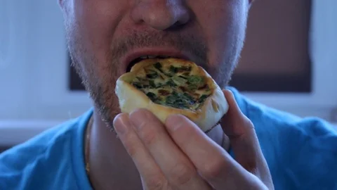 Close-up, man eats, fast food, a national dish, pie, unshaven man Stock Footage 94068310