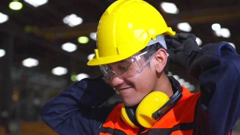 Close up man engineer wearing and adjust protective safety helmet or hard hat. Video stock 332119426