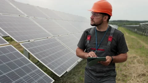 Close up of man engineer in working clothes walks on renewable energy station 스톡 동영상 156805012