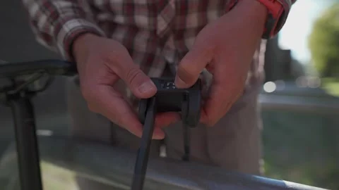 Close-up of a man entering a four-digit code on a sturdy bike lock. The bicycle Stock Footage 321480451