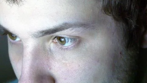 Close up of man face reading internet, with reflection of screen in her eye at Stock Photos