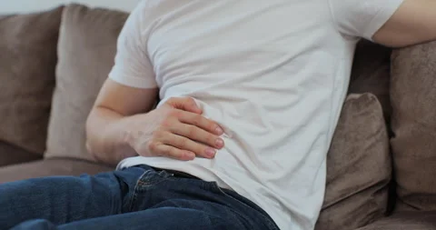 Close up of man feeling abdominal, ulcer in his tummy at home. Unrecognizable Video stock 269156229